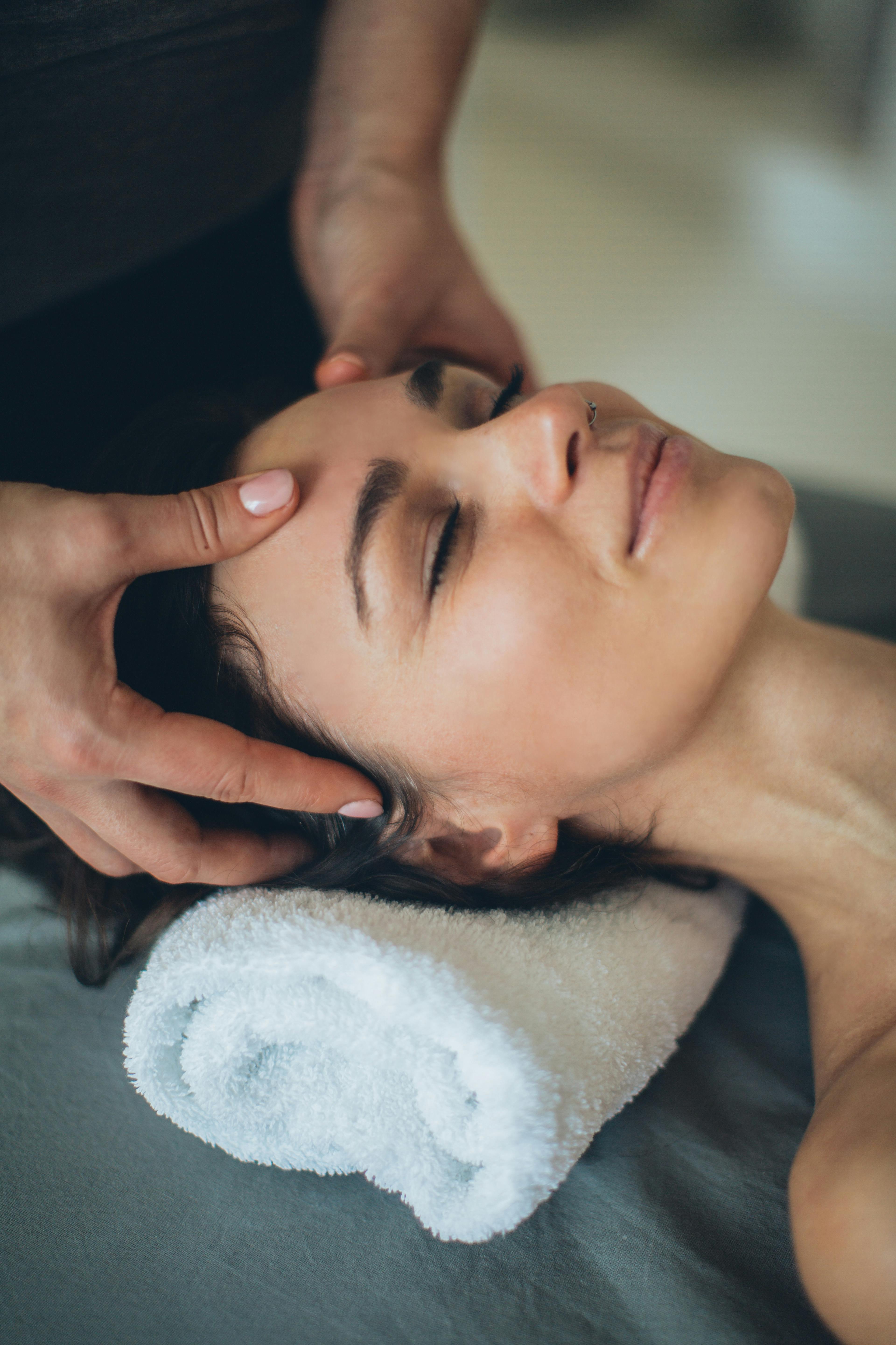 Eine Frau empfängt eine entspannende Kopfmassage.